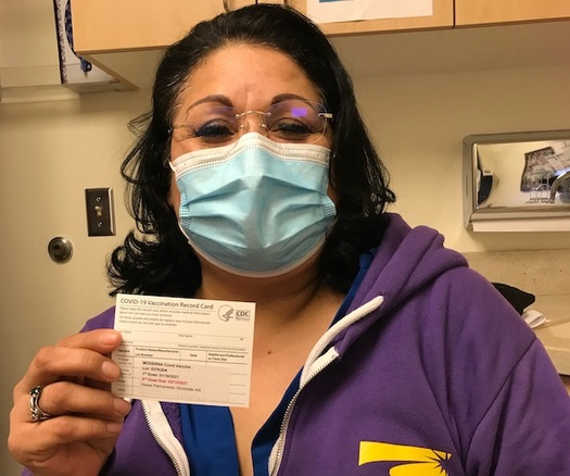 Caregiver shows vaccine card