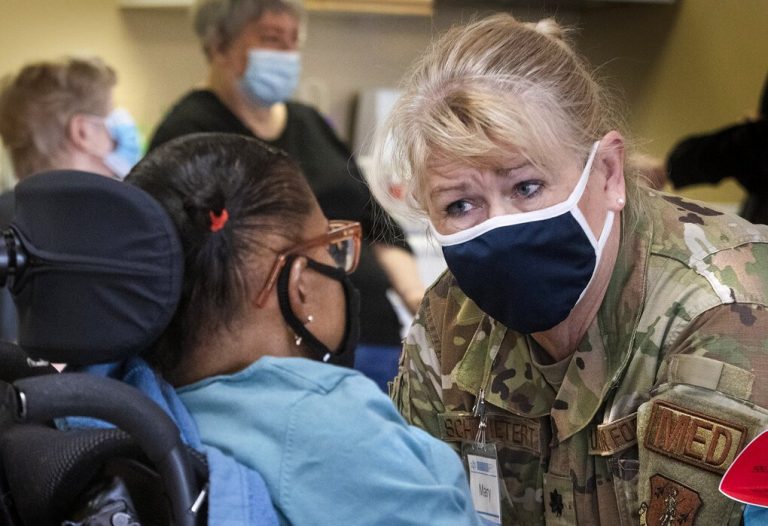 National Guard Lt. Colonel Mary Schwietert discusses the advantages and risks of receiving a COVID-19 vaccine with a Lakewood Meadows resident Wednesday. Schwietert, a physician assistant, had been helping with... (Ellen M. Banner / The Seattle Times)