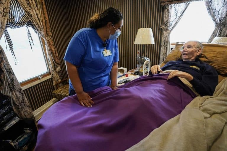 Nurse practitioner Amber Vitale talks to Arthur Katz at his home in Bellmore, New York, in May.