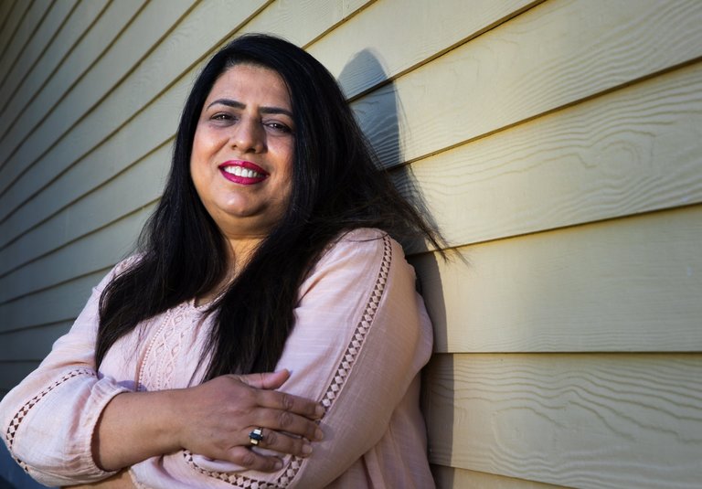 Shazia Anwar, a home care worker, stands in front of her Kent home Thursday. She has been caring for five clients throughout the coronavirus outbreak and works from 50-60 hours per week. (Ellen M. Banner / The Seattle Times)