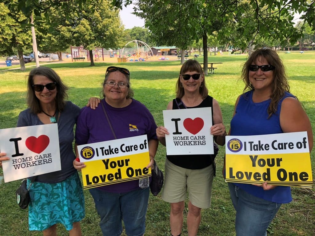 Caregivers из Монтаны держат плакаты с надписями «Я забочусь о ваших близких».