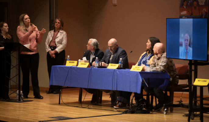 Pro-Medicaid gubernatorial candidates listen and watch as a question is asked and interpreted in ASL. (Photo by Matt Buxton)