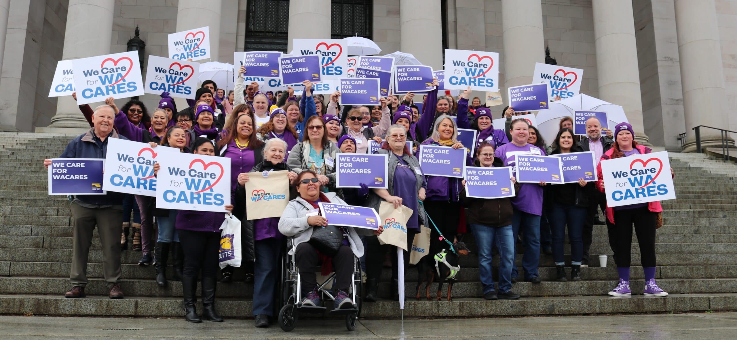 SEIU 775 caregivers standing in the rain in front of the Washington State capitol, holding signs that say 'We Care for WA Cares"